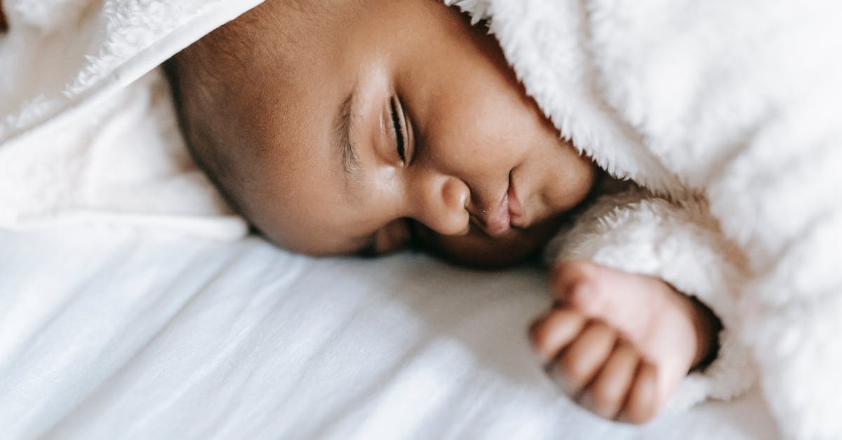 Holes inside a sweet potato - Sleeping newborn black baby lying on bed Holes inside a sweet potato - Sleeping newborn black baby lying on bed