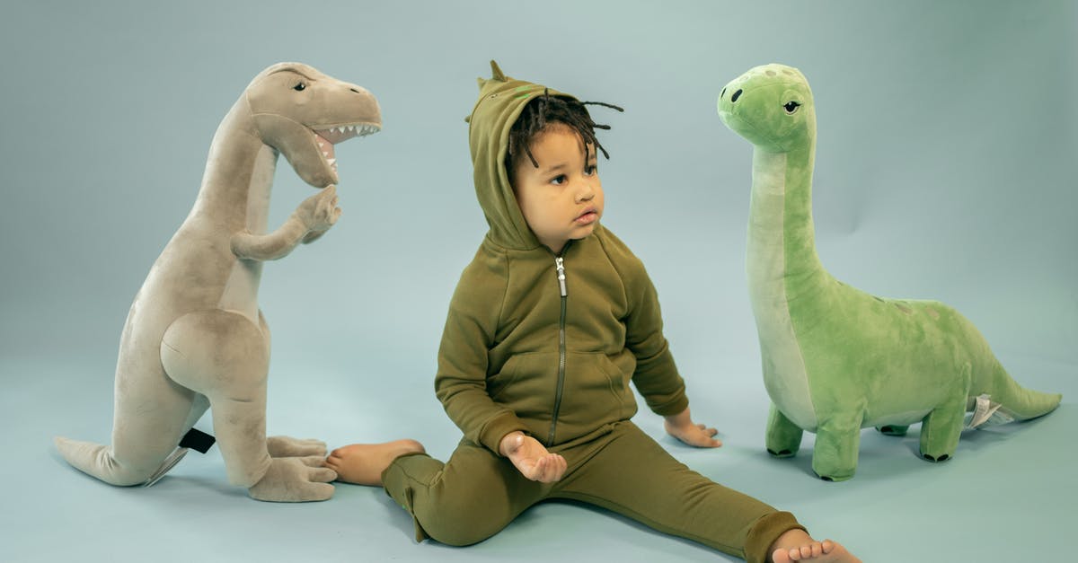 Holes inside a sweet potato - Cute black boy near dinosaurs toys Holes inside a sweet potato - Cute black boy near dinosaurs toys