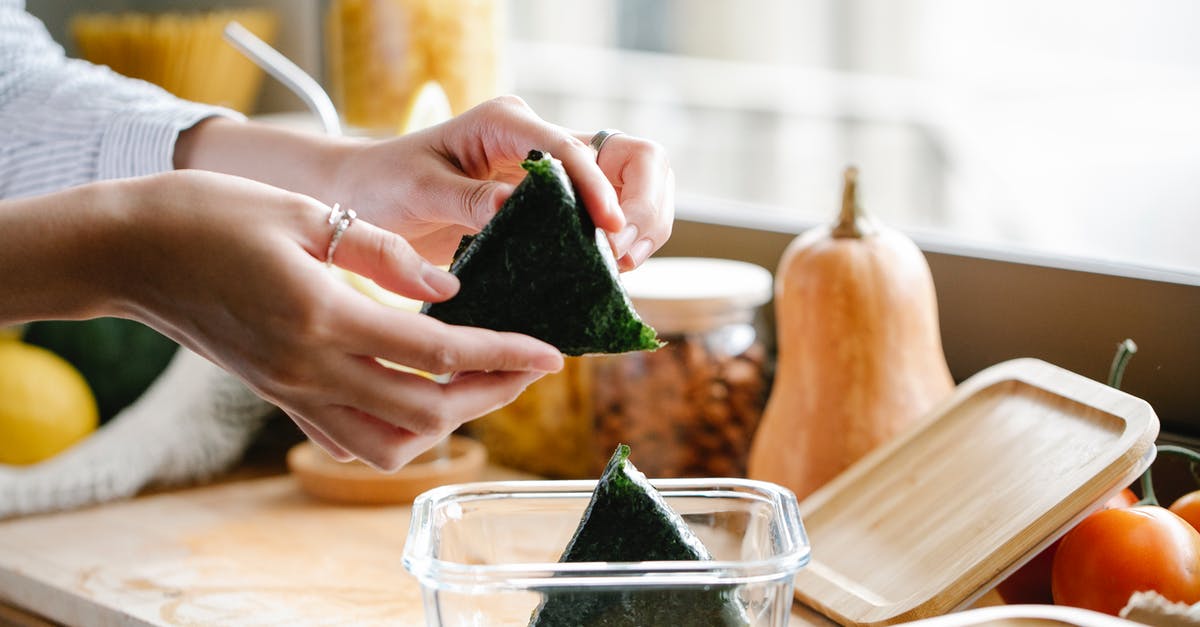 Homemade nori -> aonori? - Unrecognizable woman with onigiri at kitchen counter Homemade nori -> aonori? - Unrecognizable woman with onigiri at kitchen counter