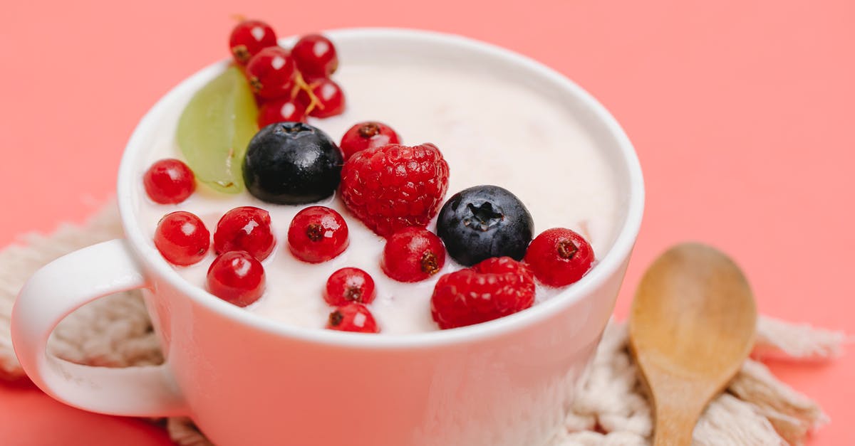 Homemade Yogurt Nutrition Info - From above of delicious homemade yogurt in white ceramic mug decorated with assorted berries and served on pink table with wooden spoon Homemade Yogurt Nutrition Info - From above of delicious homemade yogurt in white ceramic mug decorated with assorted berries and served on pink table with wooden spoon