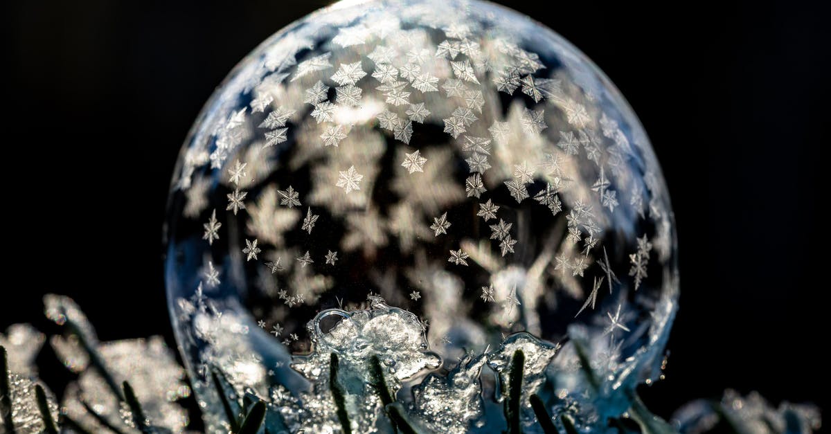 How are chemical leaveners affected by moisture and cool temperature? - Transparent frozen sphere with ice on cold ground with hoarfrost on black background How are chemical leaveners affected by moisture and cool temperature? - Transparent frozen sphere with ice on cold ground with hoarfrost on black background