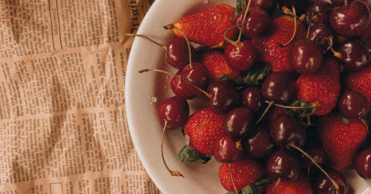 How are maraschino cherries pitted? - Strawberries and Cherries in White Ceramic Bowl on Newspaper How are maraschino cherries pitted? - Strawberries and Cherries in White Ceramic Bowl on Newspaper