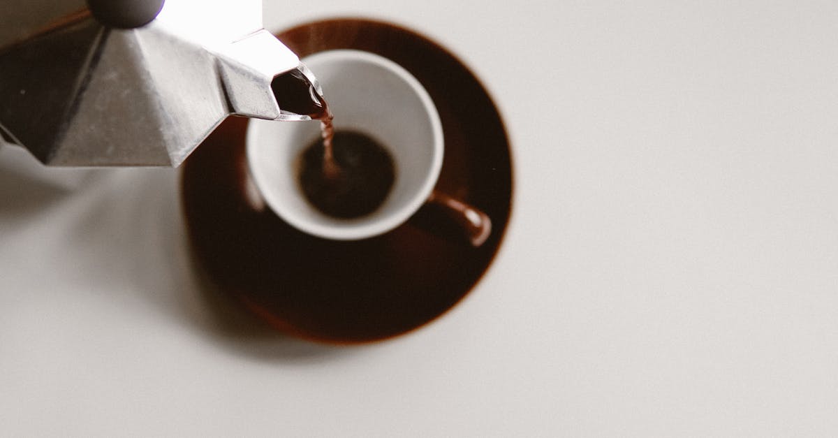 How can brown stains be removed from pots and pans? - From above of geyser coffee maker pouring freshly brewed beverage into ceramic cup placed on white table How can brown stains be removed from pots and pans? - From above of geyser coffee maker pouring freshly brewed beverage into ceramic cup placed on white table