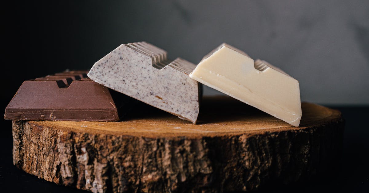 How can I avoid chocolate truffle mix curdling? - Assorted delicious sweet chocolate bars served on wooden tray against blurred gray background in studio How can I avoid chocolate truffle mix curdling? - Assorted delicious sweet chocolate bars served on wooden tray against blurred gray background in studio