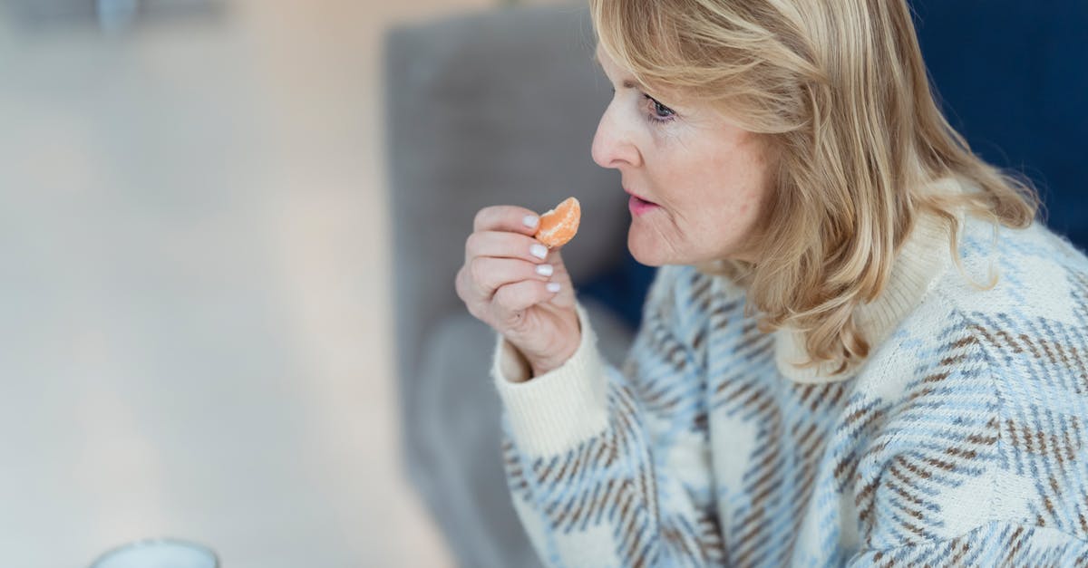 How can I concentrate citrus juice at home? - Side view of mature lady with blond hair in warm sweater eating rip healthy tangerine while drinking tea at table on cozy sofa and looking away How can I concentrate citrus juice at home? - Side view of mature lady with blond hair in warm sweater eating rip healthy tangerine while drinking tea at table on cozy sofa and looking away