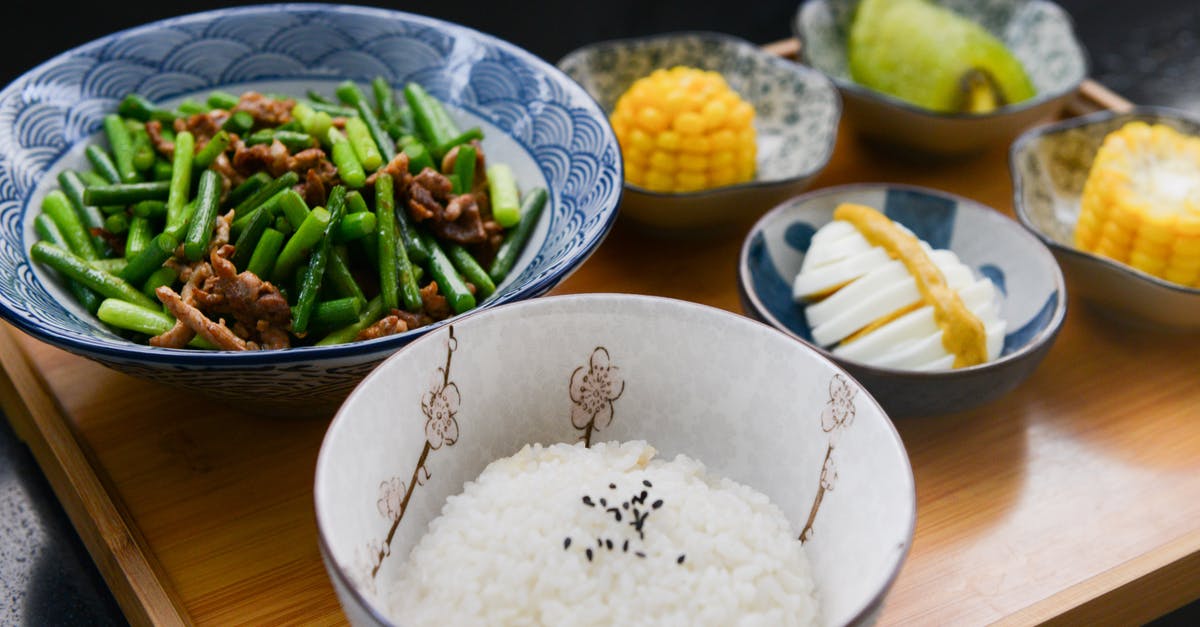 How can I cook parboiled rice in absorption method? - Rice on Bowl, Sliced-egg, Corn, and Vegetable on Table