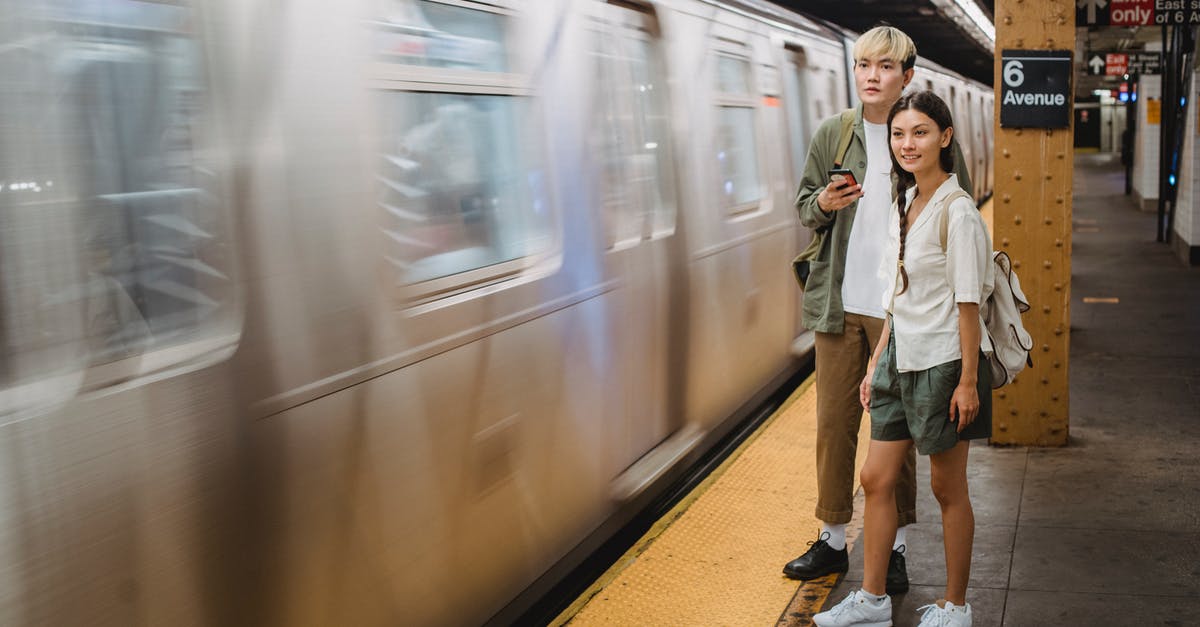 How can I cool chocolate in a couple of minutes? - Young trendy ethnic passengers waiting for train on platform How can I cool chocolate in a couple of minutes? - Young trendy ethnic passengers waiting for train on platform
