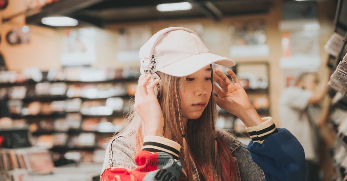 How can I cool down cooking oil after using it in a deep fryer? - Young ethnic female in stylish clothes and headphones looking down near bookshelves in library How can I cool down cooking oil after using it in a deep fryer? - Young ethnic female in stylish clothes and headphones looking down near bookshelves in library