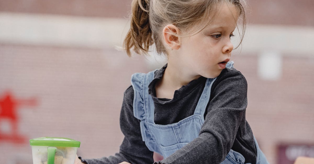 How can I create a sweet pizza that looks like pizza? - Crop cute preschool kid with ponytail in casual clothes sitting at table with colorful stationery for painting and looking away How can I create a sweet pizza that looks like pizza? - Crop cute preschool kid with ponytail in casual clothes sitting at table with colorful stationery for painting and looking away