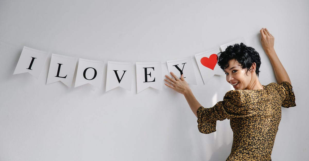 How can I decorate jelly - Cheerful female female looking at camera while hanging garland with white flags with romantic inscription on wall during Saint Valentines day How can I decorate jelly - Cheerful female female looking at camera while hanging garland with white flags with romantic inscription on wall during Saint Valentines day