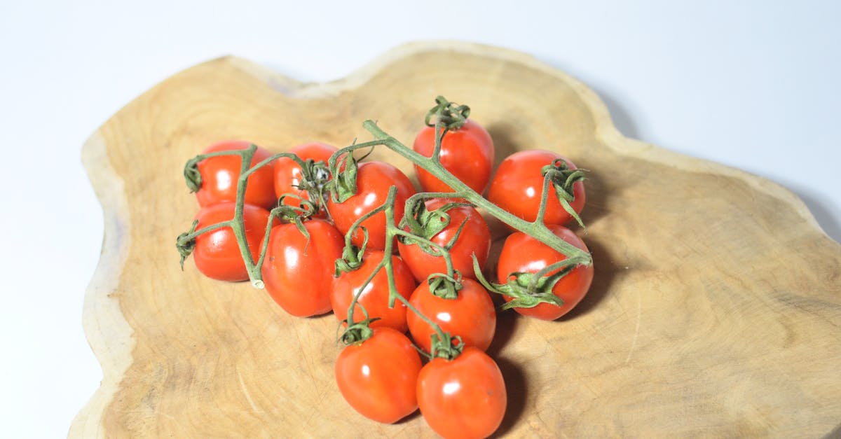 How can I dice vegetables on a small cutting board? - Tomatoes on branch placed on wooden board How can I dice vegetables on a small cutting board? - Tomatoes on branch placed on wooden board
