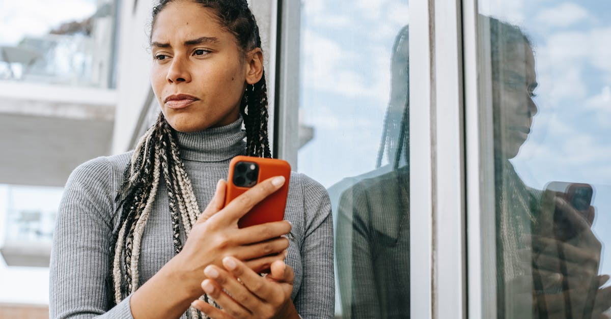 How can I identify bad peanuts before using them? - Low angle of concerned ethnic female with smartphone in stressful situation near glass wall