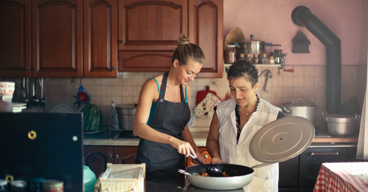 How can I improve an asian sauté / stir fry? - Daughter and senior mother standing at table in kitchen and stirring dish in frying pan while preparing food for dinner How can I improve an asian sauté / stir fry? - Daughter and senior mother standing at table in kitchen and stirring dish in frying pan while preparing food for dinner