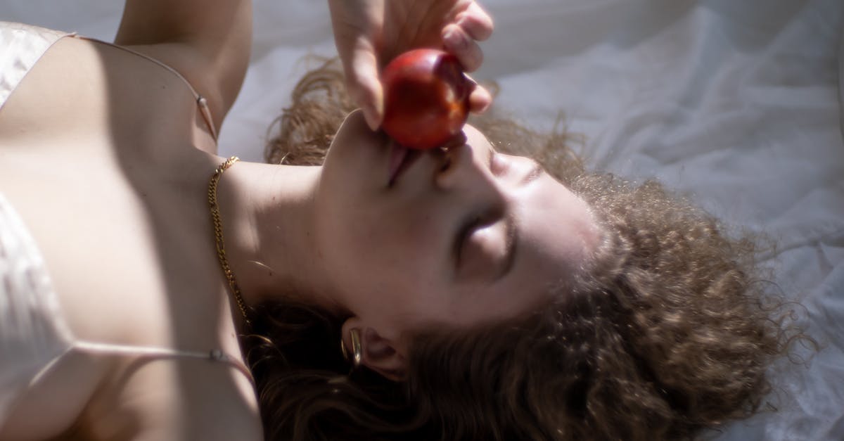 How can I keep delicate food from sticking to the grill? - From above of young female with eyes closed smelling ripe red apple while lying on white fabric How can I keep delicate food from sticking to the grill? - From above of young female with eyes closed smelling ripe red apple while lying on white fabric