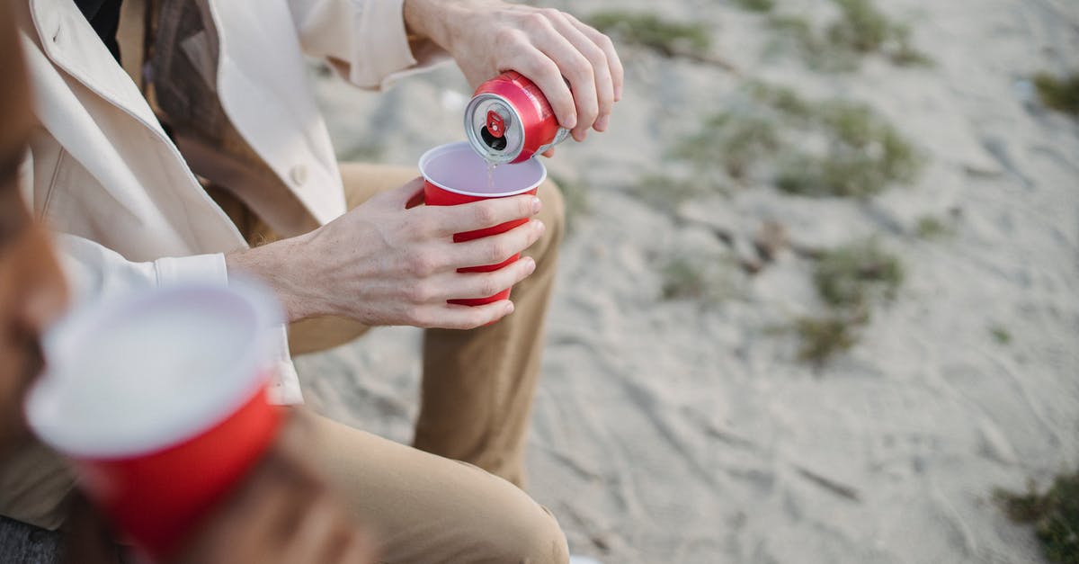 How can I keep my reheated Oats from sticking together? - High angle of crop anonymous male pouring refreshing drink into red cup while sitting on sandy shore with black friend How can I keep my reheated Oats from sticking together? - High angle of crop anonymous male pouring refreshing drink into red cup while sitting on sandy shore with black friend