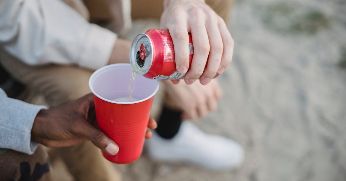 How can I keep my reheated Oats from sticking together? - From above of crop anonymous man pouring fizzy drink from can into red plastic cup of black friend while sitting on sandy ground How can I keep my reheated Oats from sticking together? - From above of crop anonymous man pouring fizzy drink from can into red plastic cup of black friend while sitting on sandy ground
