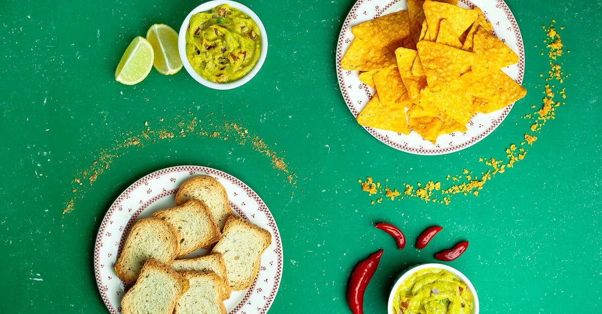 How can I make my baked tortilla chips crispier? - Flat lay of nachos near guacamole sauces and sliced white bread on plates How can I make my baked tortilla chips crispier? - Flat lay of nachos near guacamole sauces and sliced white bread on plates