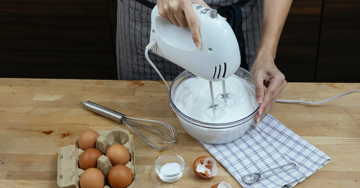 How can I make my Ice Cream "creamier"? - High angle crop anonymous female chef in apron beating eggs and preparing fluffy whipped cream in bowl while cooking in light kitchen How can I make my Ice Cream "creamier"? - High angle crop anonymous female chef in apron beating eggs and preparing fluffy whipped cream in bowl while cooking in light kitchen