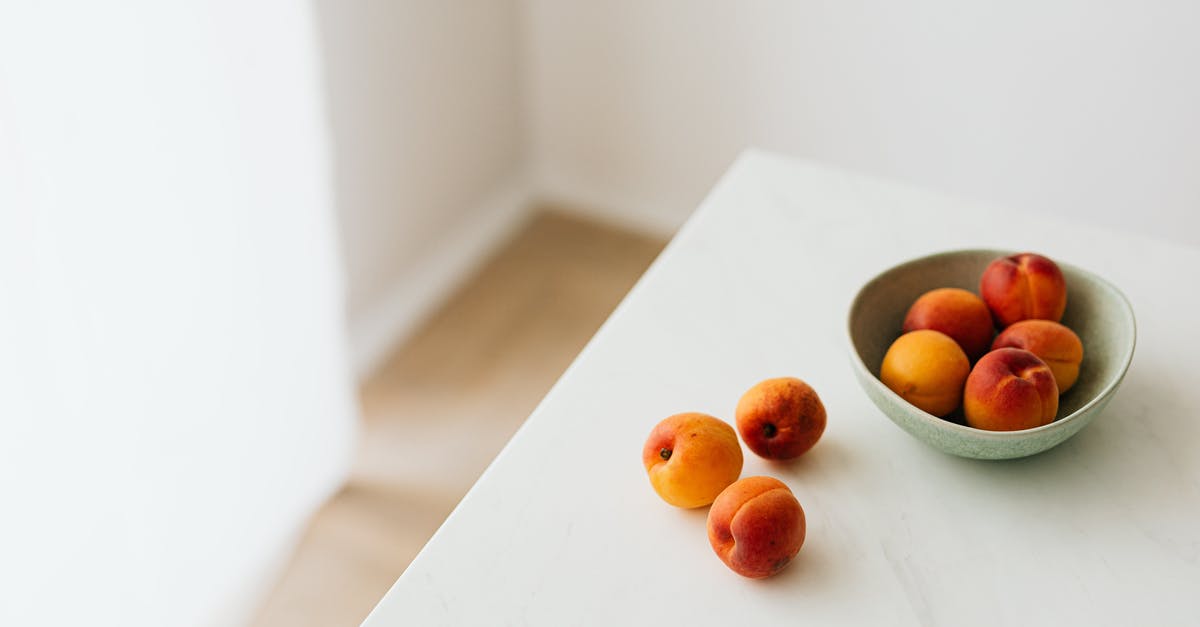 How can I minimize stirring when blending whole fruits? - Fresh apricots placed on white table How can I minimize stirring when blending whole fruits? - Fresh apricots placed on white table
