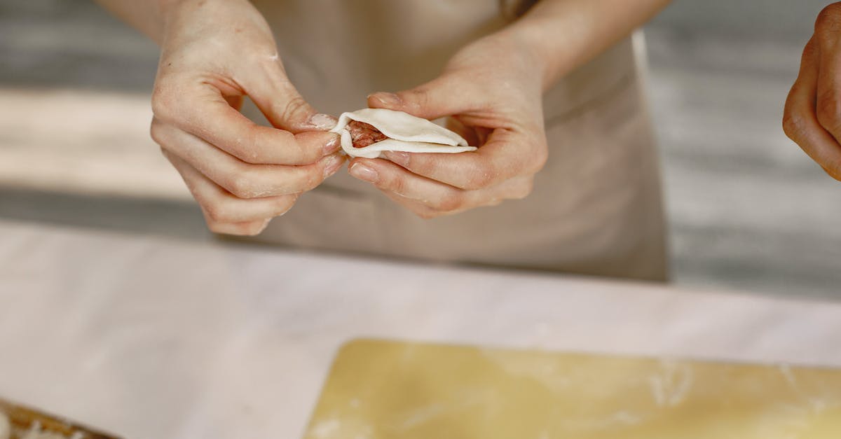 How can I prevent dough from wrapping around a dough hook? [duplicate] - A Person Wrapping a Dumpling