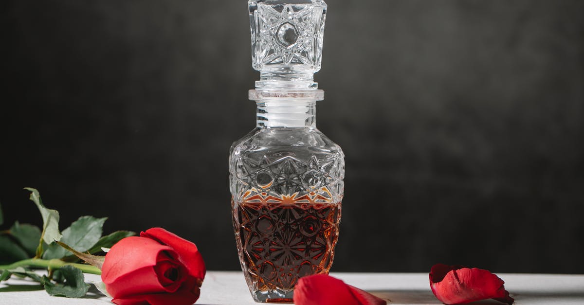 How can I remove a stuck liquor decanter stopper? - Bottle of bourbon on table with rose How can I remove a stuck liquor decanter stopper? - Bottle of bourbon on table with rose