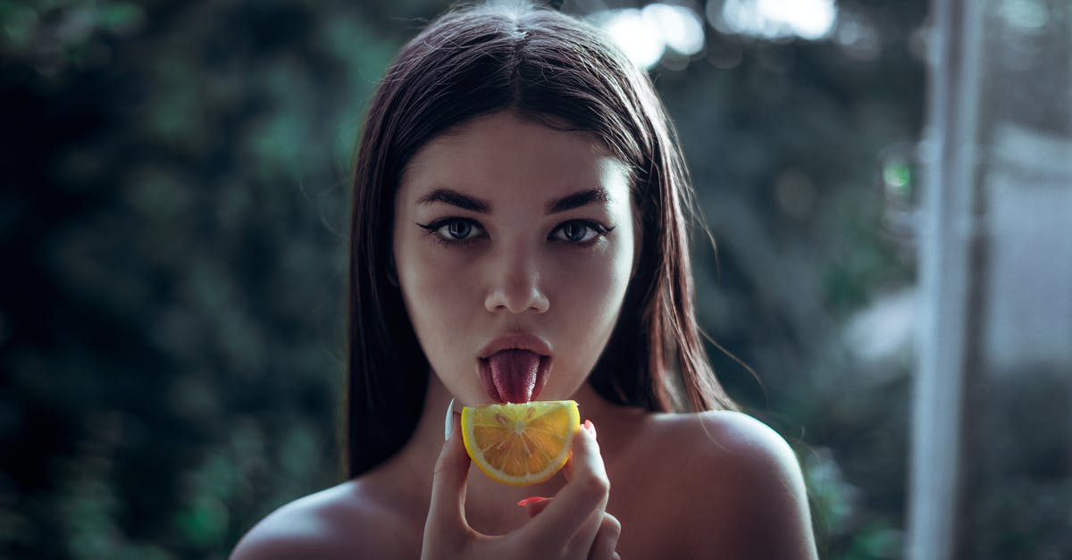 How can I tell whether a jackfruit has yellow or orange flesh by looking at the exterior of the jackfruit (i.e., without opening it)? - Selective Focus Photography of Woman Licking Orange Fruit