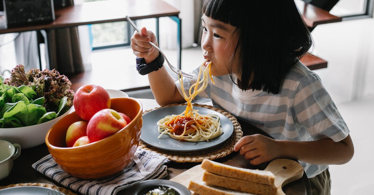 How can I turn my pasta salad into a pickle? - Cute Asian little girl enjoying delicious spaghetti during lunch at home How can I turn my pasta salad into a pickle? - Cute Asian little girl enjoying delicious spaghetti during lunch at home