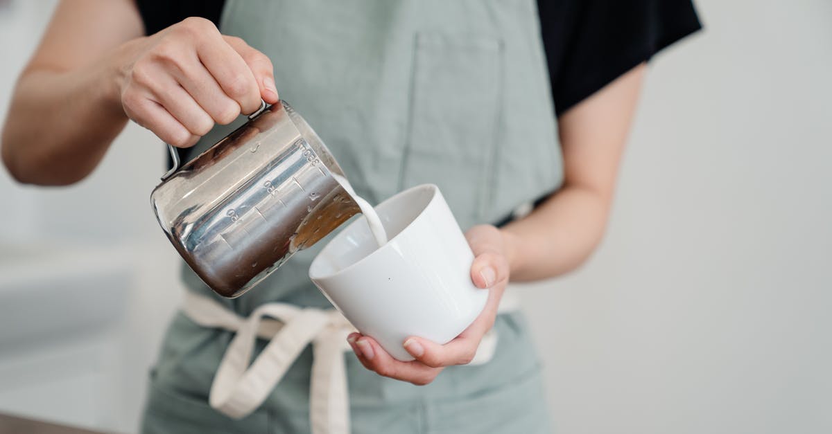 How can I use an espresso maker on an induction cooktop? - Crop person pouring milk into cup in kitchen How can I use an espresso maker on an induction cooktop? - Crop person pouring milk into cup in kitchen