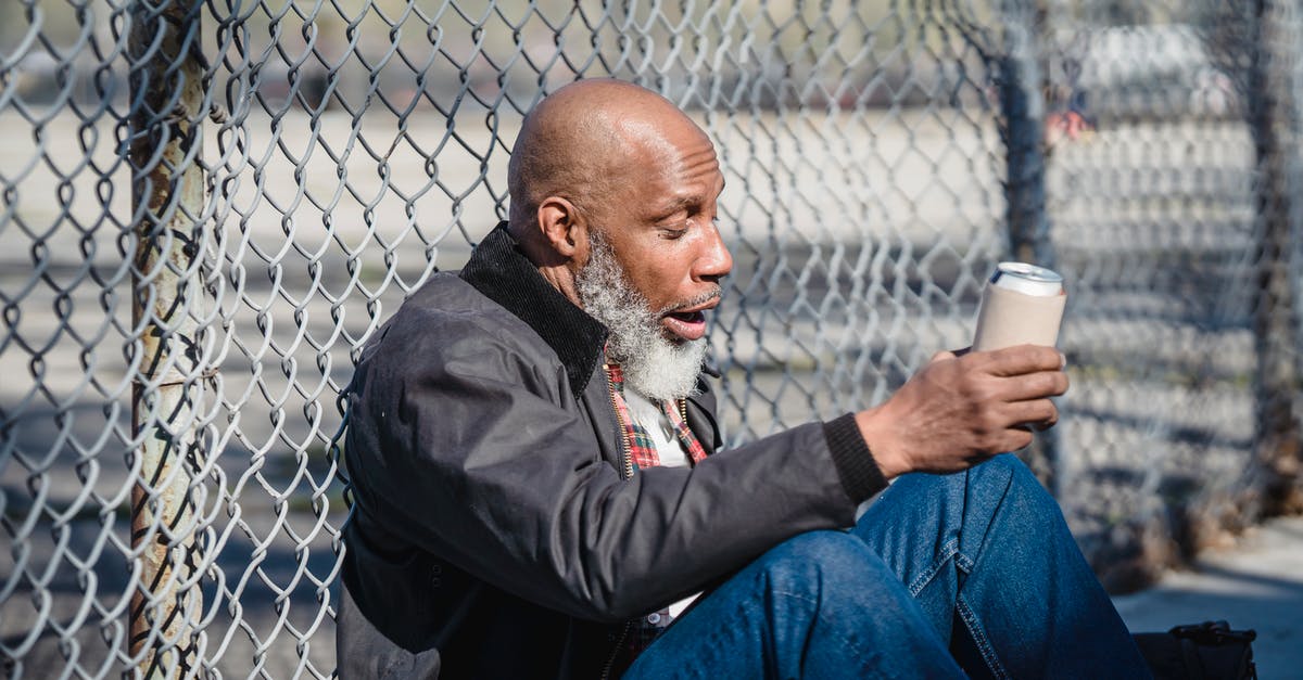 How can one make a reasonable curry with limited spices and poor quality equipment? [closed] - Side view of black homeless bald man sitting on street with beer can in hand and leaning on wire railing