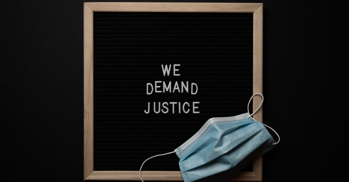 How can we prevent the steaming of tiffin when we put chapatis in? - Top view arrangement of protective face mask placed on black framed image with bright white text We Demand Justice on black background