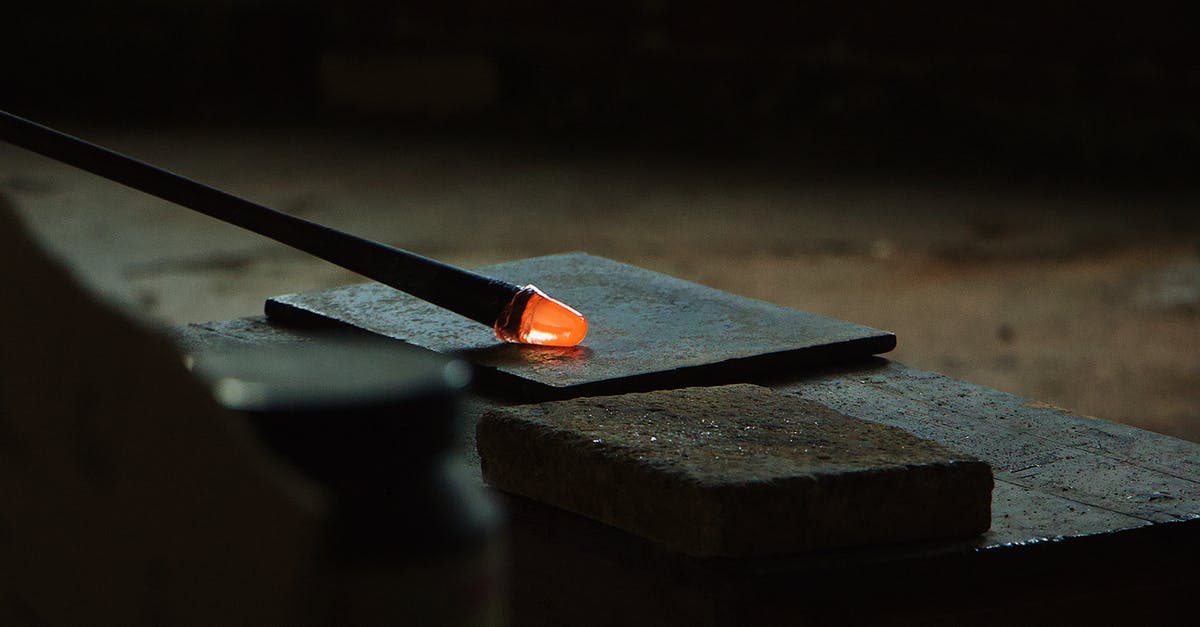 How can you pipe hot melted candy into free-form shapes? - Glassblowing pipe in dark workshop How can you pipe hot melted candy into free-form shapes? - Glassblowing pipe in dark workshop