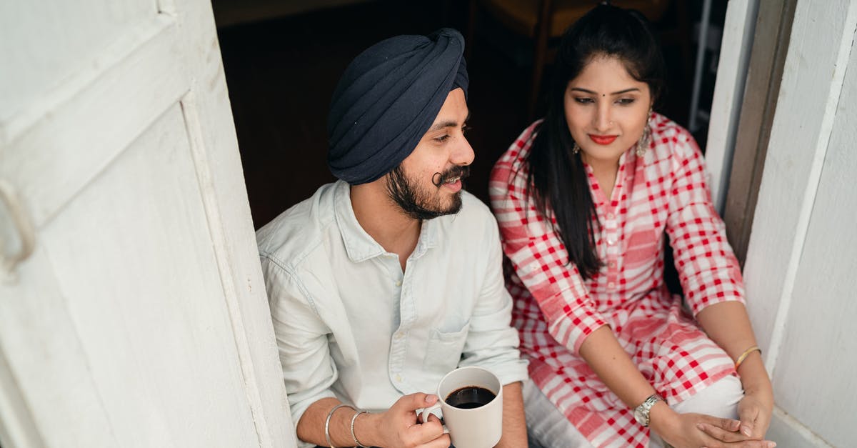 How can you tell when flour has gone off? - From above of good looking Indian wife listening to husband sharing news with cup of coffee in hand while both sitting at doorstep of house How can you tell when flour has gone off? - From above of good looking Indian wife listening to husband sharing news with cup of coffee in hand while both sitting at doorstep of house