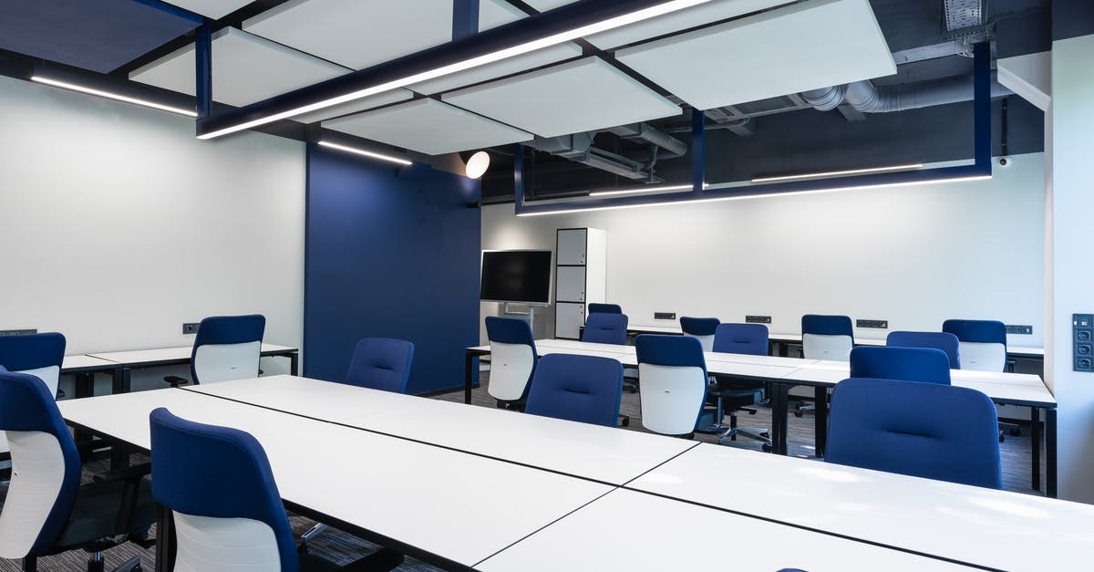 How do baking supply companies blanch their hazelnuts? - Interior of modern spacious workspace with long white tables and blue armchairs placed near monitor with black screen in business center How do baking supply companies blanch their hazelnuts? - Interior of modern spacious workspace with long white tables and blue armchairs placed near monitor with black screen in business center