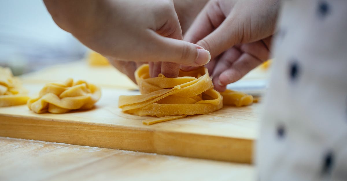 How do chefs come up with recipes for good food? - Crop unrecognizable female cook creating nest from homemade tagliatelle egg pasta placed on wooden cutting board while preparing dinner in kitchen How do chefs come up with recipes for good food? - Crop unrecognizable female cook creating nest from homemade tagliatelle egg pasta placed on wooden cutting board while preparing dinner in kitchen