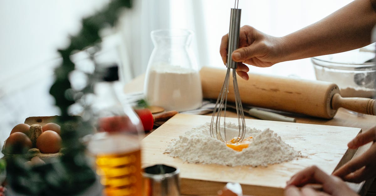 How do egg whites help to keep fats inside a cake? - Crop unrecognizable ladies standing near table and whipping flour with egg for recipe on cutting board at home How do egg whites help to keep fats inside a cake? - Crop unrecognizable ladies standing near table and whipping flour with egg for recipe on cutting board at home