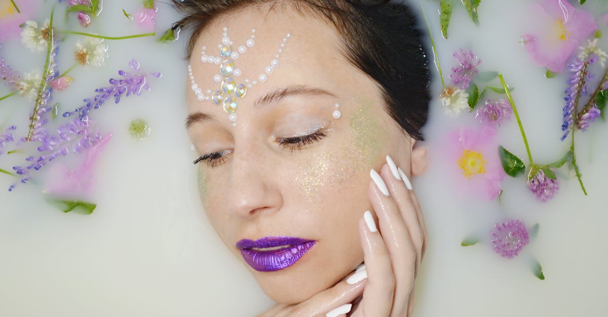 How do I clean burnt milk from a glass-ceramic stove? - Top view of gentle female with purple lips and rhinestones on forehead lying in milk water with violet twigs during skincare procedure How do I clean burnt milk from a glass-ceramic stove? - Top view of gentle female with purple lips and rhinestones on forehead lying in milk water with violet twigs during skincare procedure