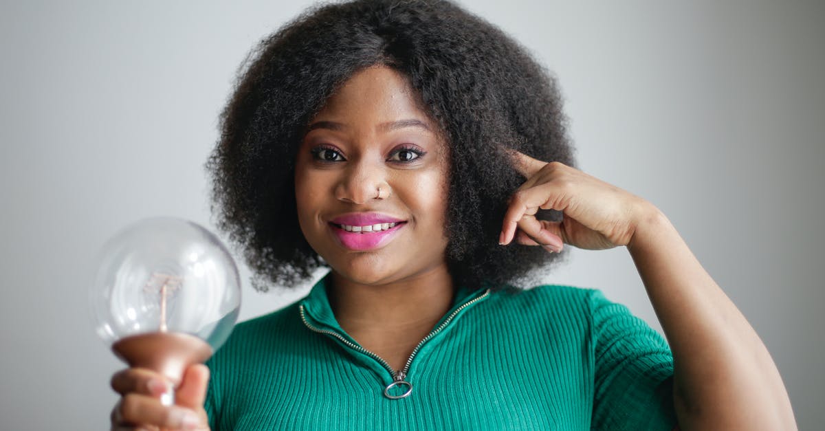 How do I cook brain to achieve a firmer texture? - Positive young African American lady holding light bulb in hand on gray background How do I cook brain to achieve a firmer texture? - Positive young African American lady holding light bulb in hand on gray background