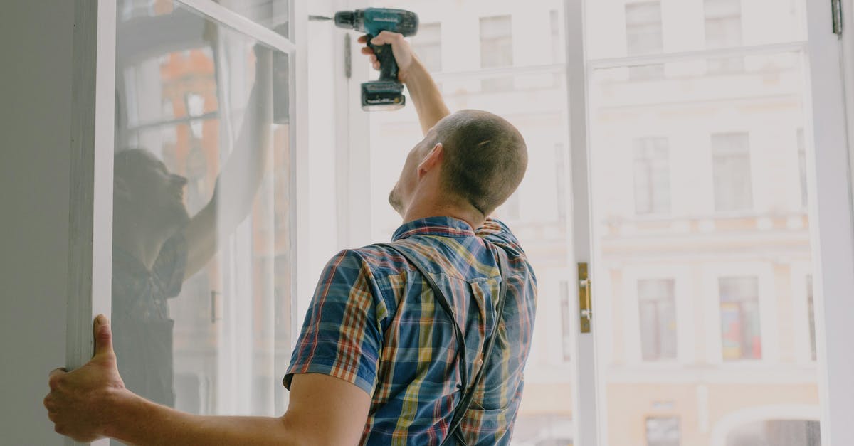 How do I fix my flat sourdough loaf? - Back view of worker in checkered shirt drilling window frame during renovation process in apartment How do I fix my flat sourdough loaf? - Back view of worker in checkered shirt drilling window frame during renovation process in apartment