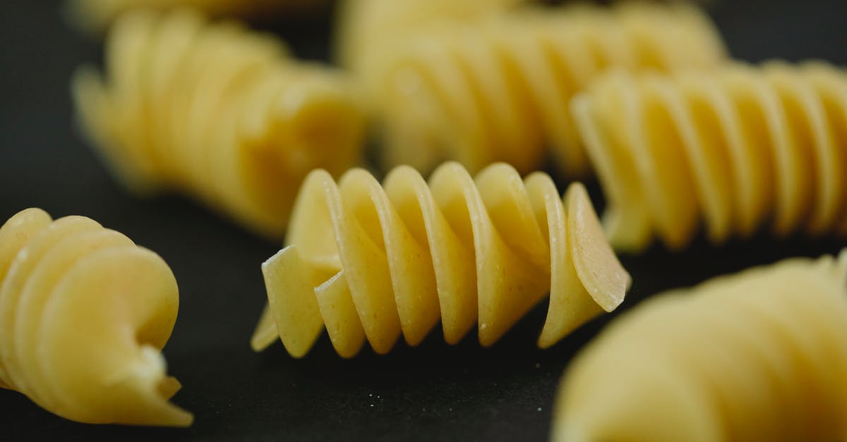 How do I get rid of excess flour on my dried pasta shapes? - Closeup of heap of uncooked dried traditional Italian pasta fusilli on blurred background How do I get rid of excess flour on my dried pasta shapes? - Closeup of heap of uncooked dried traditional Italian pasta fusilli on blurred background