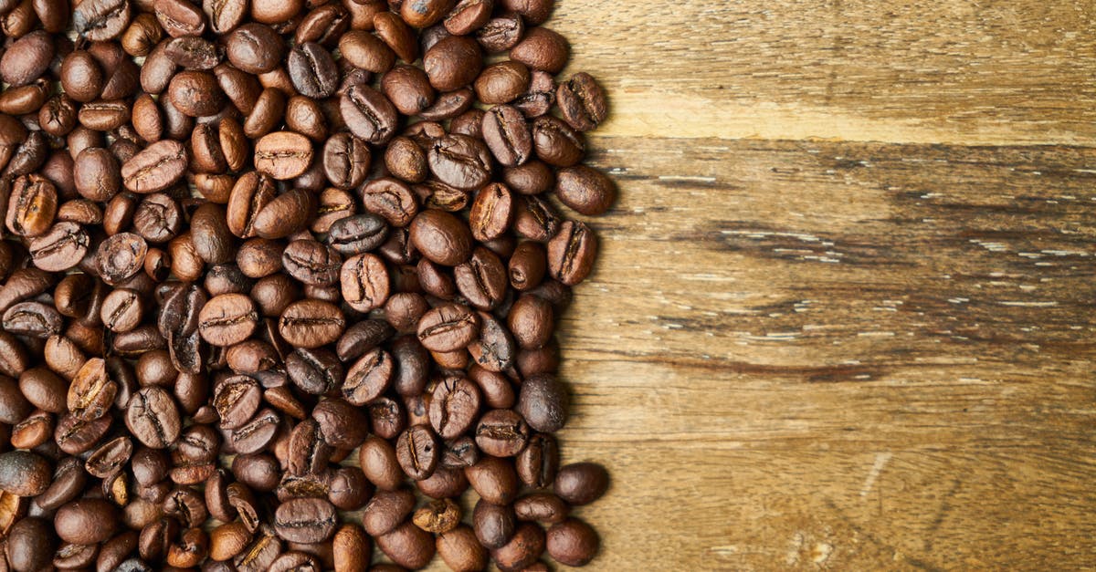 How do I infuse cappuccino with real vanilla bean during brew? - Top view of shiny aromatic roasted coffee beans scattered on rustic wooden table How do I infuse cappuccino with real vanilla bean during brew? - Top view of shiny aromatic roasted coffee beans scattered on rustic wooden table
