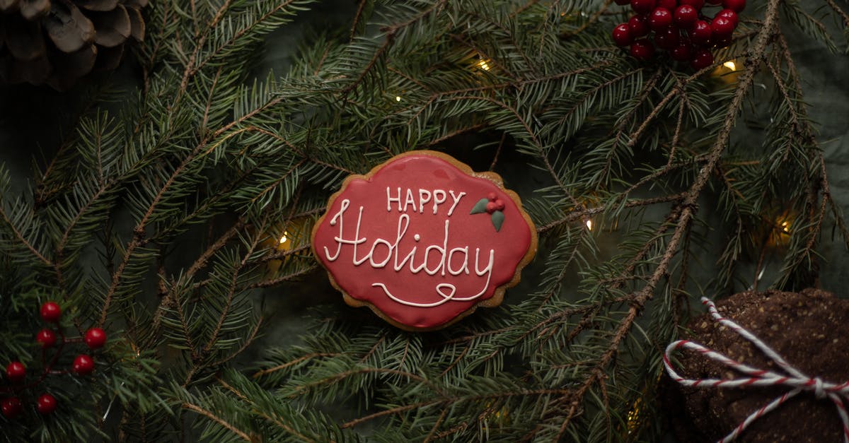 How do I keep Glaze for Gingerbread cookies translucent - Happy Holiday inscription on biscuit on fir sprigs with garland How do I keep Glaze for Gingerbread cookies translucent - Happy Holiday inscription on biscuit on fir sprigs with garland