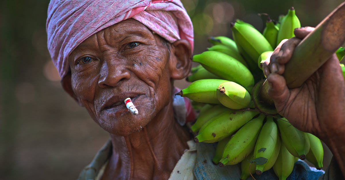 How do I keep track of how old food is? - Man Wearing Blue Top Holding Bunch of Unripe Bananas How do I keep track of how old food is? - Man Wearing Blue Top Holding Bunch of Unripe Bananas