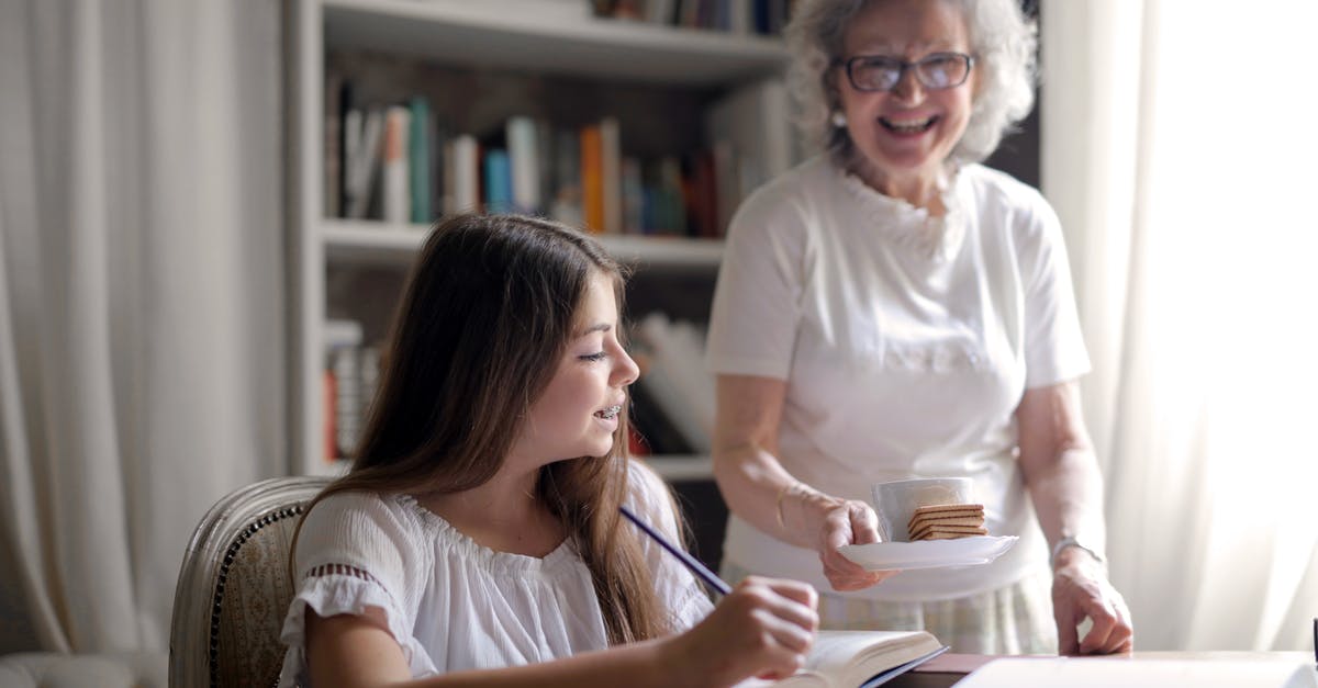 How do I keep track of how old food is? - Cheerful grandmother in glasses and casual clothes smiling at camera while giving pastry on plate and mug of tasty beverage to joyful teenager sitting at table with books and exercise book and study in light cozy living room How do I keep track of how old food is? - Cheerful grandmother in glasses and casual clothes smiling at camera while giving pastry on plate and mug of tasty beverage to joyful teenager sitting at table with books and exercise book and study in light cozy living room