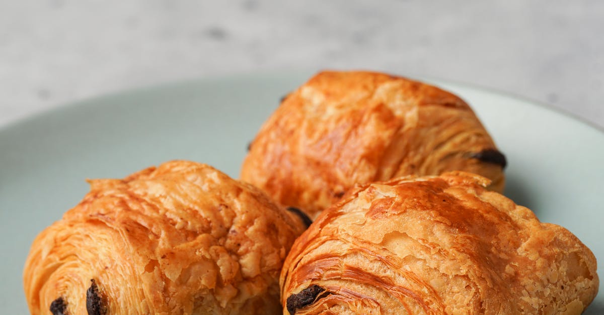 How do I make a flaky croissant? - Three Brown Bread on Ceramic Plate