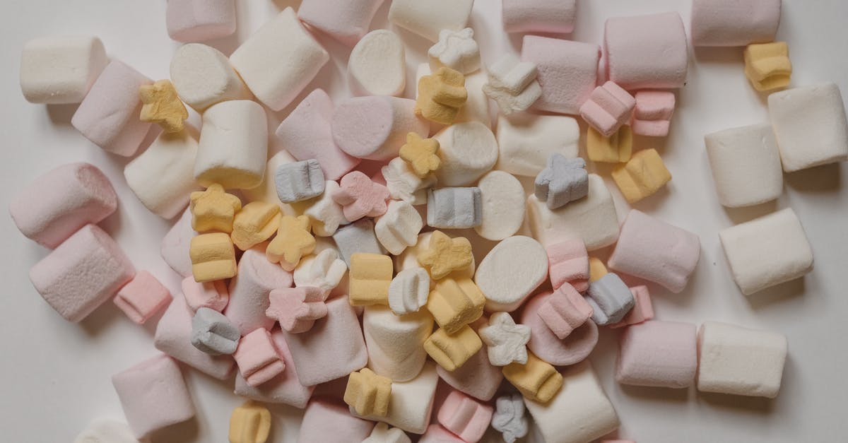 How do I make candy apples not sticky? - Many tasty marshmallows heaped on white table How do I make candy apples not sticky? - Many tasty marshmallows heaped on white table