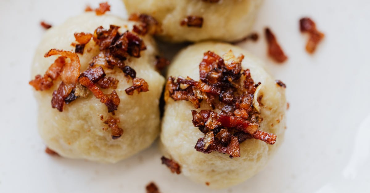 How do I make crispy potato pancakes? - Delicious dumplings with fried bacon slices on plate How do I make crispy potato pancakes? - Delicious dumplings with fried bacon slices on plate