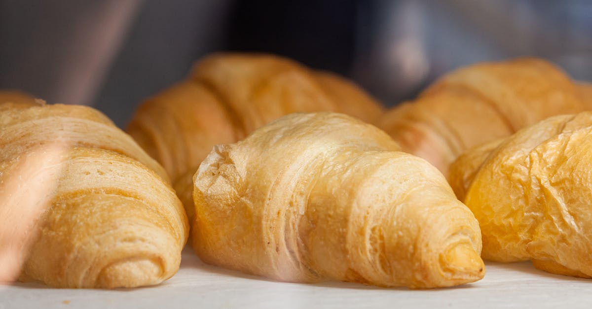 How do I make french fries that are crispy inside and out? - Delicious fresh croissants with golden crust placed on white surface in light cafe