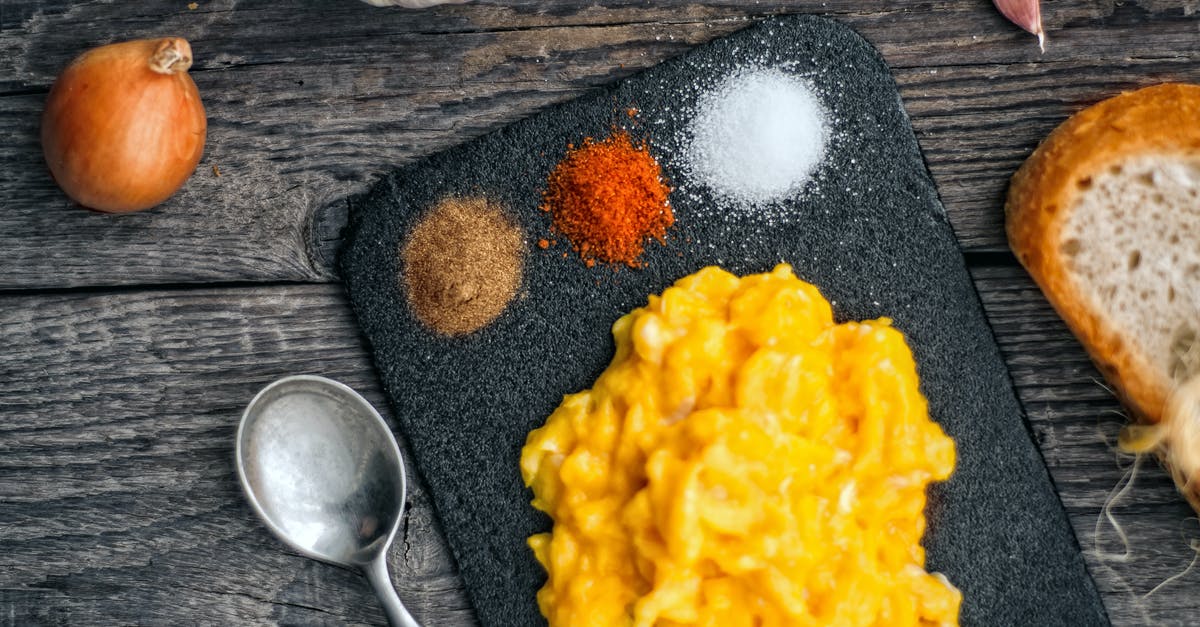 How do I make scrambled egg whites more like scrambled eggs? - Top view of delicious scrambled eggs served on black board with colorful spices on wooden table with onion and slice of bread