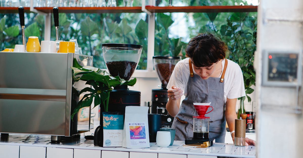 How do I prepare (any) coffee with desired caffeine concentration? - Thoughtful female barista with brown hair in apron pouring aromatic alternative coffee while working in light cafe in daytime How do I prepare (any) coffee with desired caffeine concentration? - Thoughtful female barista with brown hair in apron pouring aromatic alternative coffee while working in light cafe in daytime
