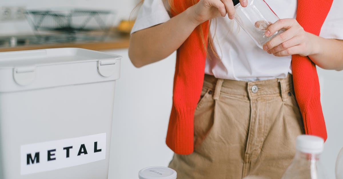 How do I reduce kitchen temperature during cooking? - Woman unscrewing lid from bottle while sorting trash How do I reduce kitchen temperature during cooking? - Woman unscrewing lid from bottle while sorting trash